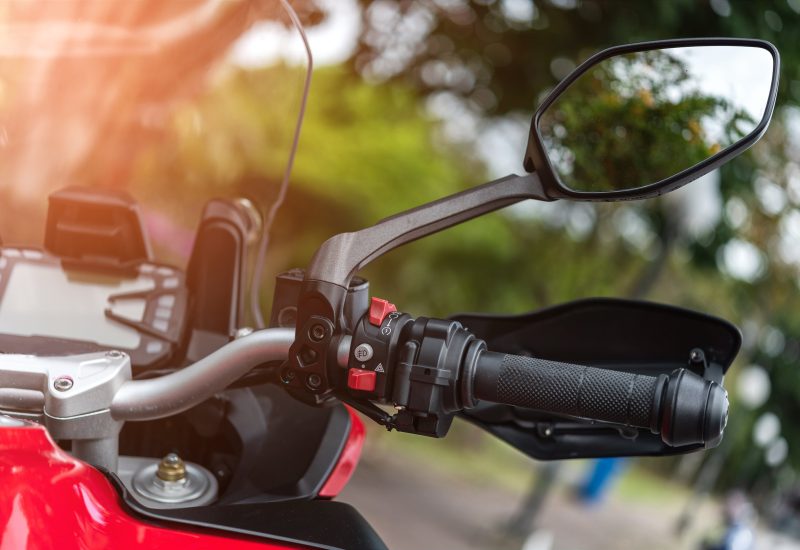 Motorcycle handlebar with button control  and mirror, selective focus.