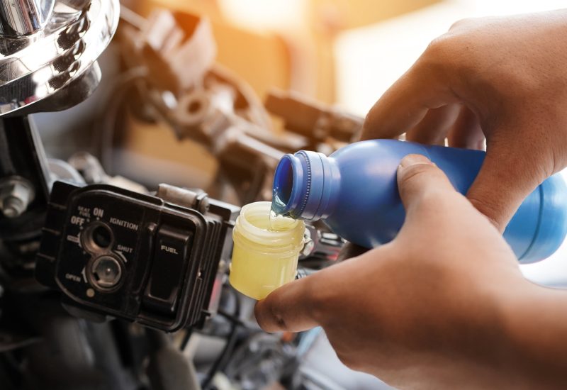 Mechanic Check and Add Brake fluid to motorcycle or scooter , selective focus . auto mechanic uses to check and repair or Maintenance motorcycle brake disc system