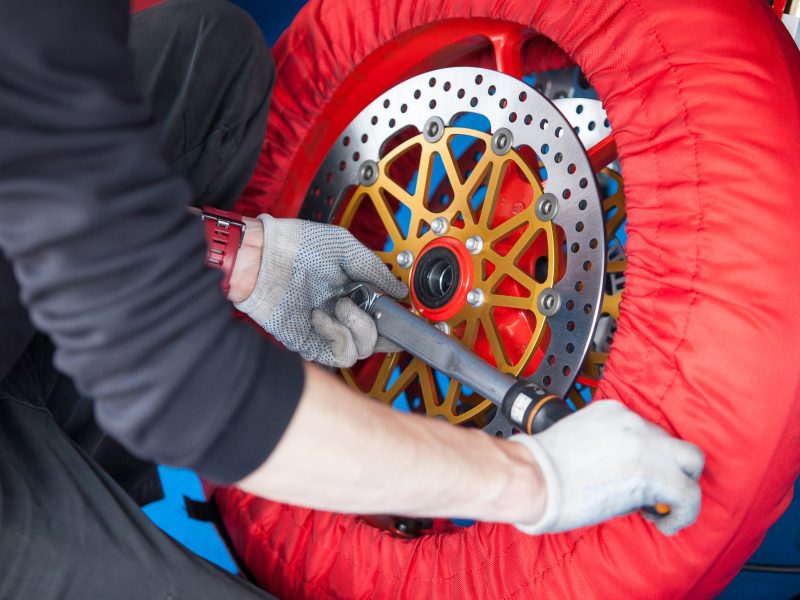 Repair of the wheel of a sports bike, hands on mechanics with the tool